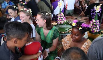 A group of people participating in what seems to be a traditional ceremony, surrounded by floral decorations.