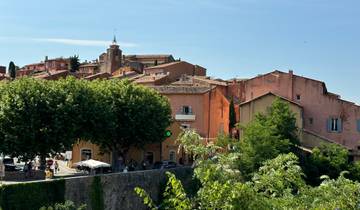 A colorful village with trees and church tower.
