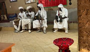 A group of traditional musicians wearing white robes and turbans.
