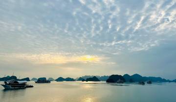 Boats on the serene waters of Halong Bay with limestone karsts.