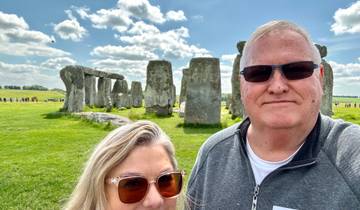 A couple posing in front of Stonehenge.