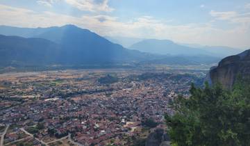 View of a valley and distant mountains from a high vantage point.