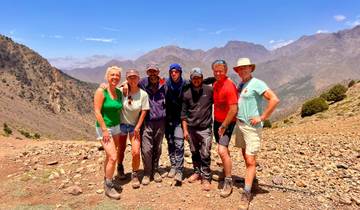 Group of people smiling in a rocky mountain setting.