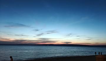 Sunset over the ocean with colorful clouds.