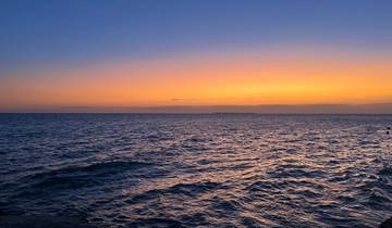 Beautiful sunset over the ocean with an island in the distance.