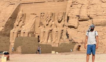 Man posing in front of Abu Simbel statues.
