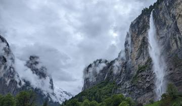 Dramatic view of tall waterfalls and misty cliffs.