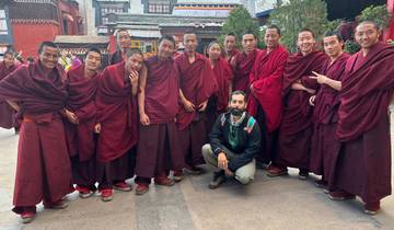 Group of monks in red robes with a tourist.