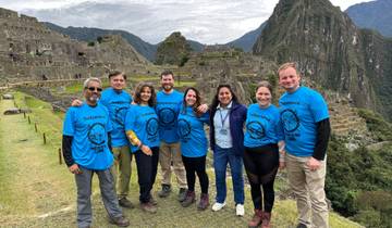 A group of people posing in front of Machu Picchu.