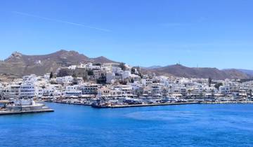 A scenic view of a coastal town with white buildings and a bright blue sea.