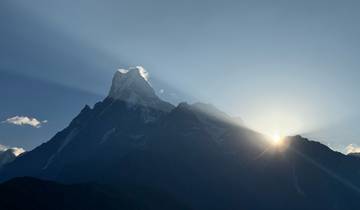 Majestic mountain peak with sun rising behind in Nepal.