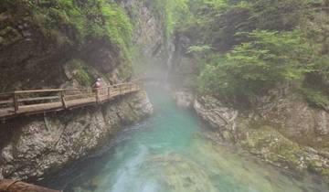 Wooden walkway over a turquoise river in a gorge.