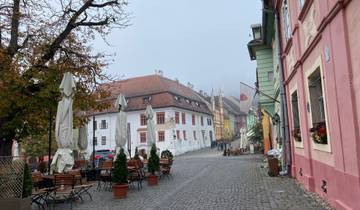 Cobbled street with colorful buildings and outdoor seating.
