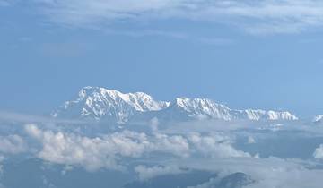 Distant snow-capped mountains with fluffy clouds.
