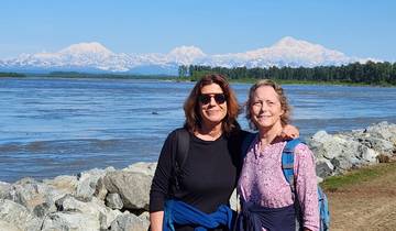 Two women posing with mountains in the background.