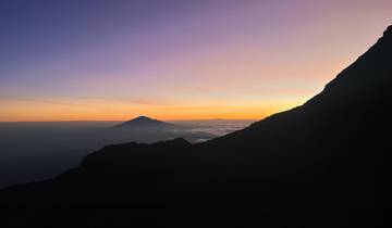 Silhouette of mountains during sunset with vibrant sky.