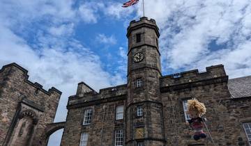 Historic clock tower and castle under a blue sky.