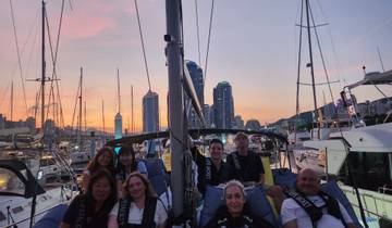 Group on a boat with a city skyline at sunset.