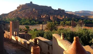 Ancient clay town with arches and greenery.