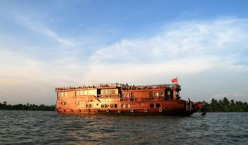 Large wooden cruise boat on a river at sunset.