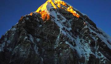 Snowy mountain peak illuminated by the sun.