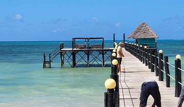 Wooden pier extending into the ocean with clear blue water.