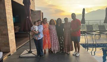 Group of people by a pool during sunset.