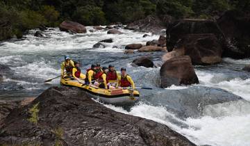 Group of people white-water rafting in a river.