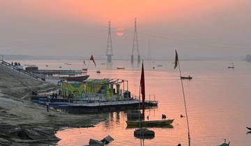 Scenic view of a river with boats and a sunset in the background.