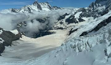 Aerial view of snow-covered mountains and clouds.