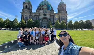 Group of people posing in front of a grand historic building.