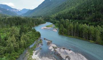 A winding river through a lush green forested valley.