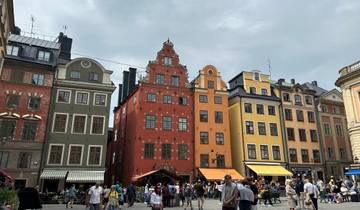 Colorful buildings in a busy city square with people strolling.