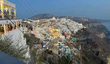 Aerial view of a lit-up city against a dusk sky.