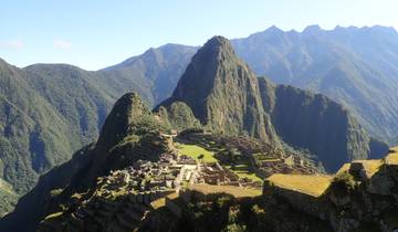 Panoramic view of Machu Picchu with surrounding mountains.