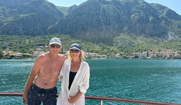 Couple on a boat with a coastal village in the background.