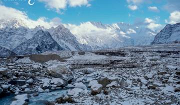 Snow-capped mountain range with clouds.