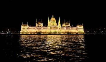 The Hungarian Parliament illuminated at night reflecting in the river.