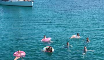Group of people swimming in clear blue water.
