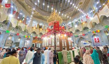 Interior of a shrine with ornate decorations and a large crowd
