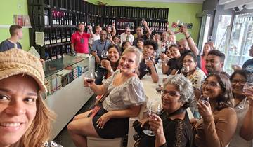 Group of people enjoying wine tasting in a lively setting.