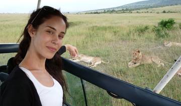 Woman on safari with lions in the background.