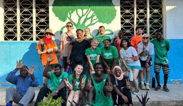 Group photo of people posing in front of a painted wall.