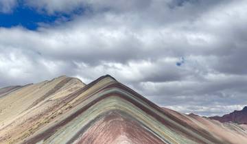 Colorful mountain range under a cloudy sky.