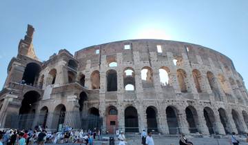The Colosseum in Rome with tourists gathered below.