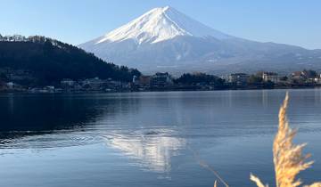 Mount Fuji reflected in a serene lake with a clear sky.