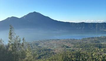 View of a mountain and a lake with forested surroundings.