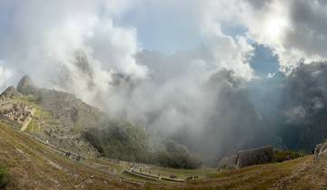 Panoramic view of Machu Picchu shrouded in clouds.