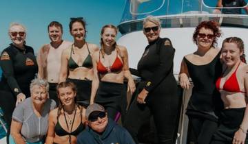 A large group of people posing on a boat, likely on a tour.