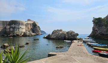 A picturesque view of rocks and sea near an old fort.